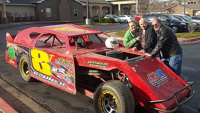 Thomas Yarnell stands next to the USRA Modified driven by Terry Bruner with his son, Ralph, and a nurse from Caris Healthcare Hospice.